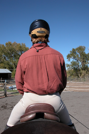 Photo 1. This rider's seat is unlevel, dropping off on the right side. Notice that the seam of her britches does not line up with the center of the saddle, which is level and in line with the horse's spine.