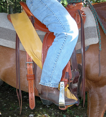 Photo 3. The tension of the Equiband can be adjusted by tying it a bit shorter if necessary. With this rider the Equiband is simply preventing her from swinging the fender forward. Her ankle is already under her hip when the fender is hanging vertically. Note that on a Western saddle the Equiband goes behind the cantle, on an English saddle it goes over the cantle.