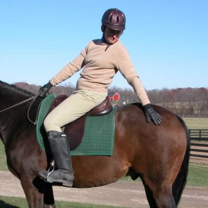 Photo 3. The rider is reaching back toward the horse’s hip joint. Notice she is looking toward her hand and her foot is quietly resting in the stirrup.